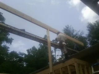Carpenter setting a ridge beam over a new addition frame — Ice Dam Removal by Roofing Brothers in Kimberton