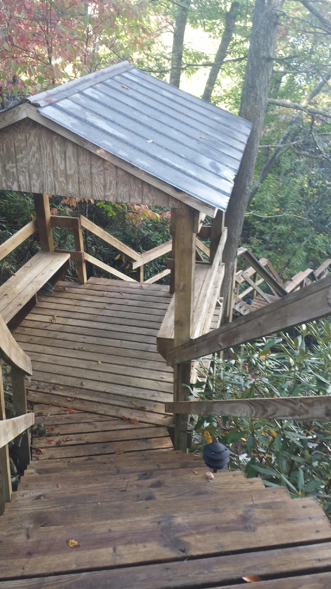 Metal roofed shelter over wooden steps on a wooded walkway — Skylight Repair & Installation work by our crew in Kimberton